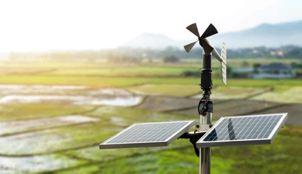 Anemômetro de palhetas giratórias com agricultura ao fundo