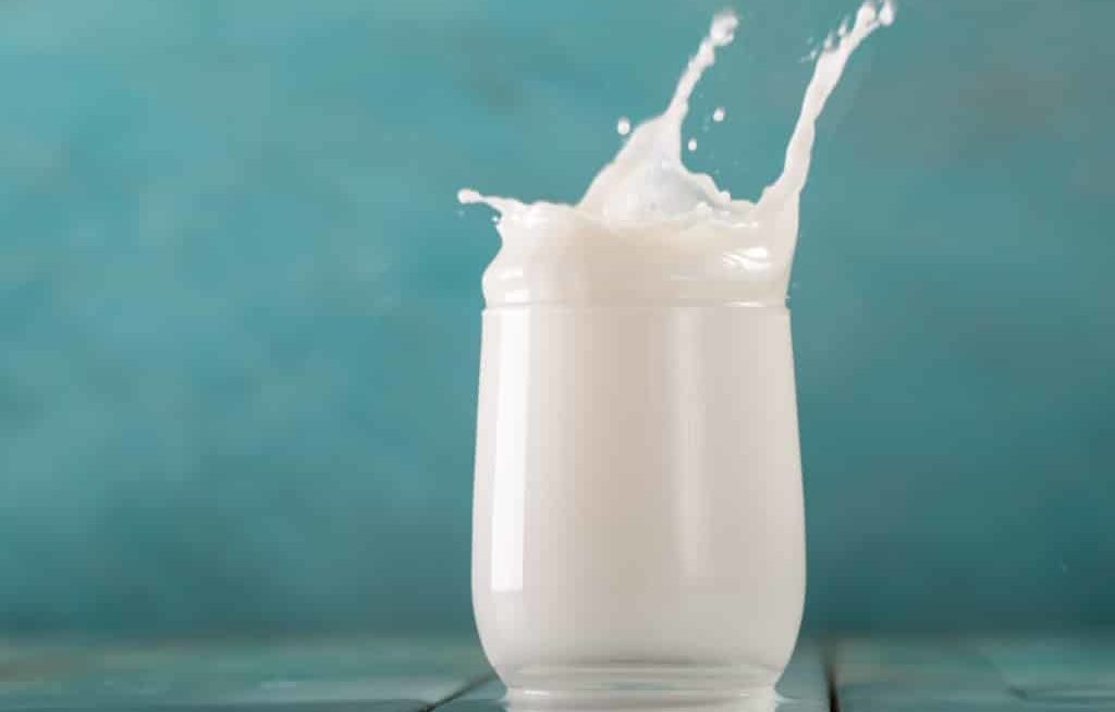 copo cheio de leite jorrando