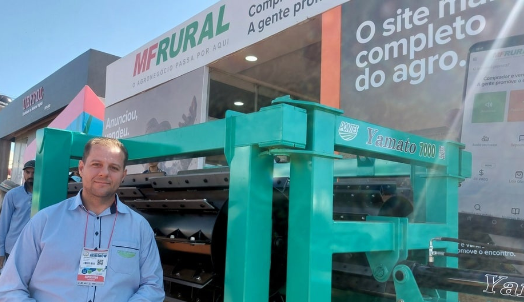 Eduardo Pontes ao lado do equipamento em exposição no estande do MF Rural na Agrishow 2023