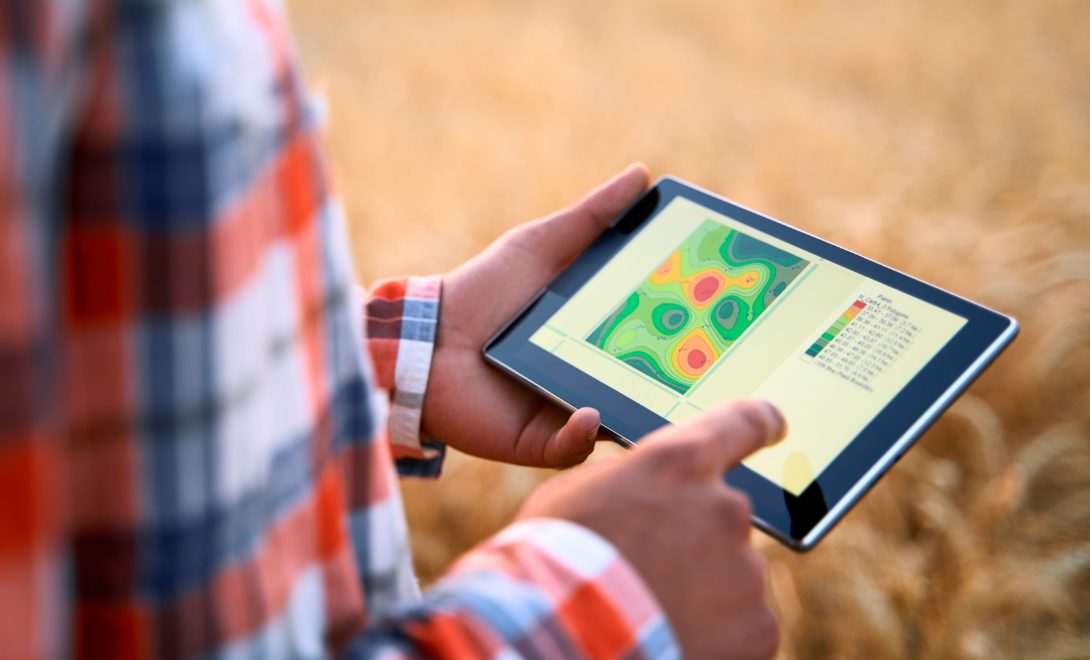 Homem com tablet visualizando mapa de recomendação de fertilizantes